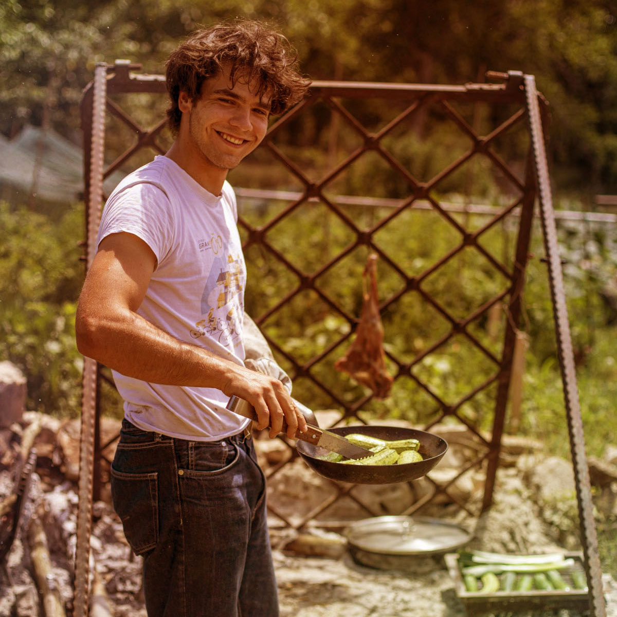 Bor Winkler cooking courgettes over the outdoor hearth at Kumparička
